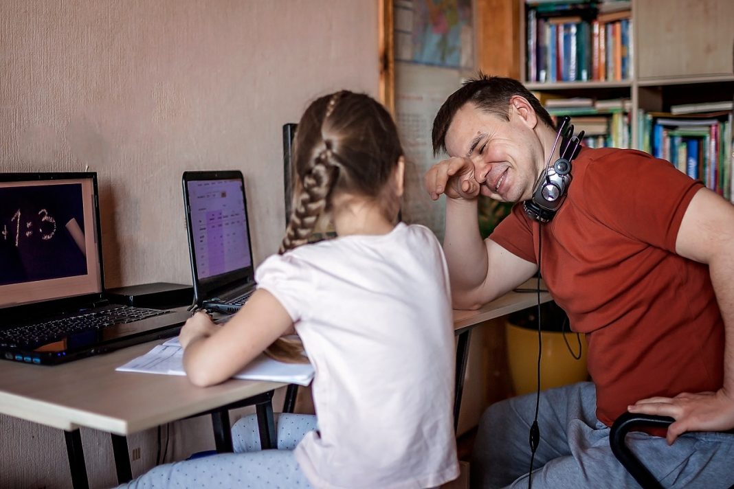 Digitális oktatás: eszköz és kompetencia híján nem működött A middle-aged father working online near his cute daughter durin