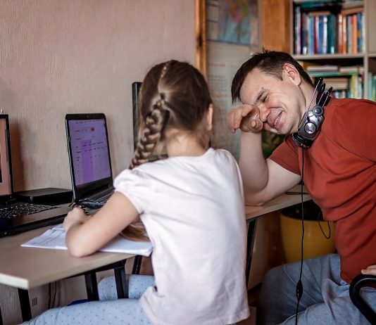Digitális oktatás: eszköz és kompetencia híján nem működött A middle-aged father working online near his cute daughter durin