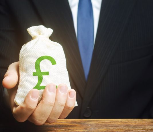 Anglia gazdasági termelése közel 10 százalékkal csökkent – ez a legnagyobb visszaesés 300 év alatt Man holds out a Pound sterling GBP money bag. Provision of money on credit, grant. Project financing. Donations. Financial social assistance. Payment purchases, profits dividends. Business investment