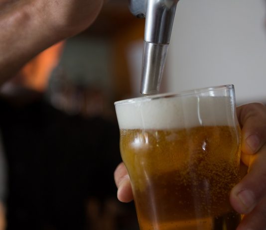 Nyolcezer embert küld el a Heineken Mid-section of brewer filling beer in beer glass from beer pump in bar