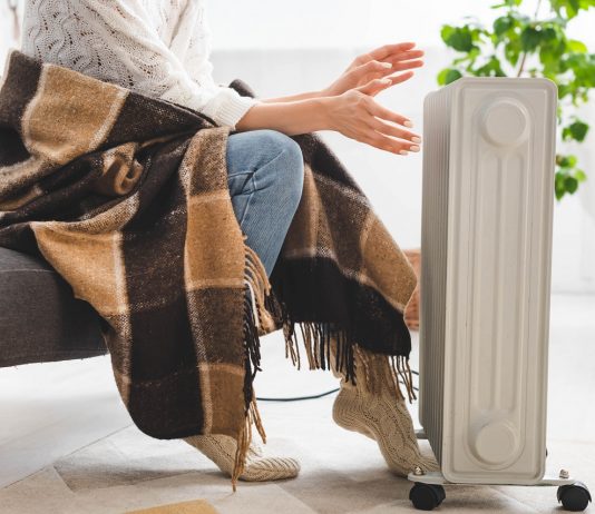 Kabátban, sálban dolgoznak a nővérek és az orvosok a Fiumei úti baleseti intézetben cropped view of girl with blanket warming up with heater in cold room