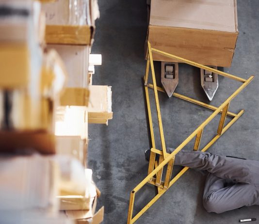 Hányan veszítették életüket munkavégzés közben? – Baleseti statisztikák, csökkenő számok, 2020 jót is hozott Warehouse worker after an accident in the storage. Man in uniform lying down on the ground
