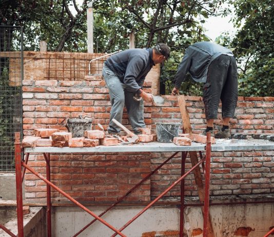 Új eszközt vethet be márciustól a hatóság a bejelentés nélkül foglalkoztatókkal szemben Worker placing and installing bricks on exterior wall on house
