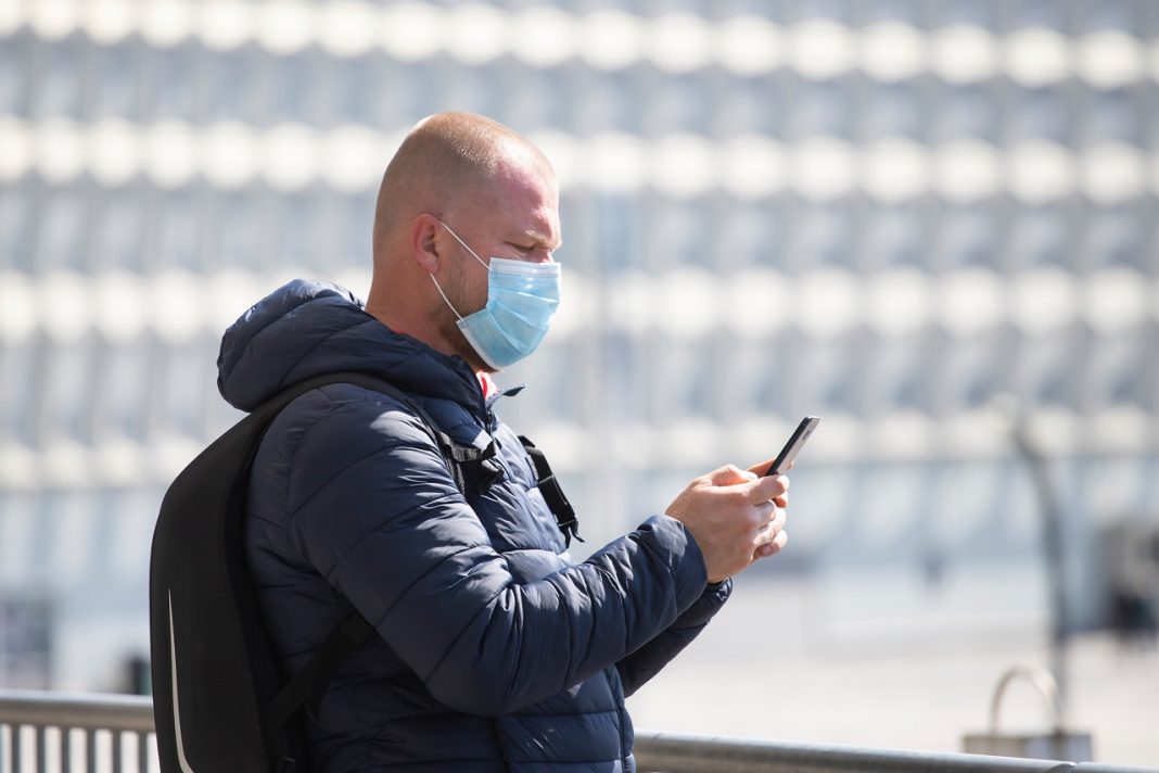 Tourist man in a medical surgical mask in the city.