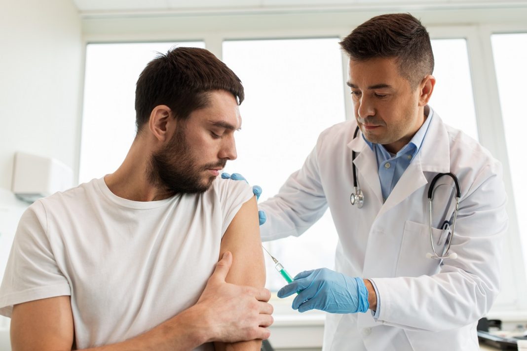 patient and doctor with syringe doing vaccination