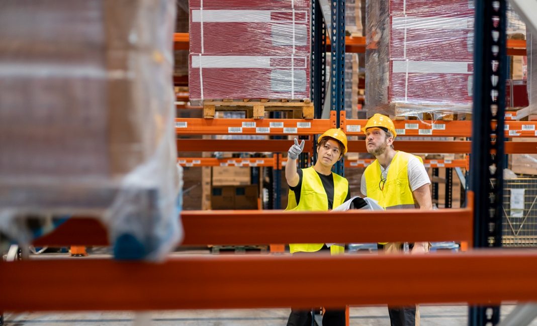Warehouse workers establish order of packages on shelves