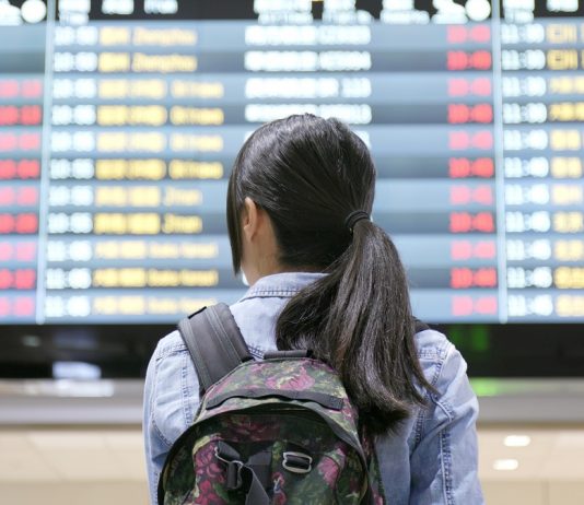 Milliárdokat bukik az Unió, ha nem nyitja meg a határokat az észak-amerikaiak előtt Young woman traveler looking for the flight number number at airport