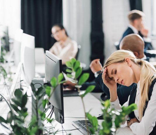 Keresőképtelenség igazolása – hogyan? sick young woman suffering from headache at workplace
