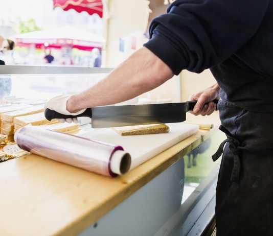 A fővárosban a programozó és könyvelő, vidéken a bolti eladó és a gépkezelő a legkeresettebb szakmák Shopkeeper chopping cheese in store