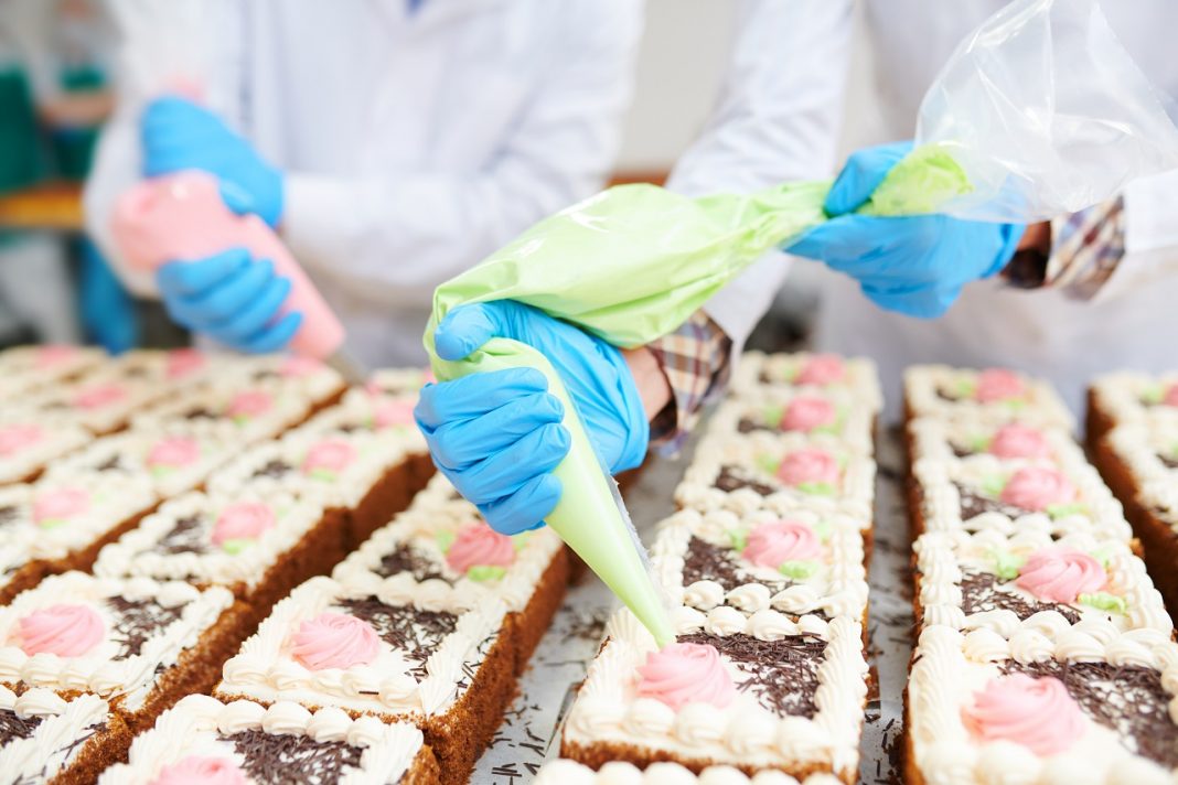 Cakes decorating in confectionery factory
