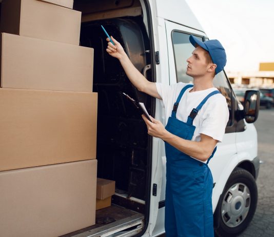 A céges autókon múlik a fenntarthatóság Deliveryman in uniform check boxes in the car