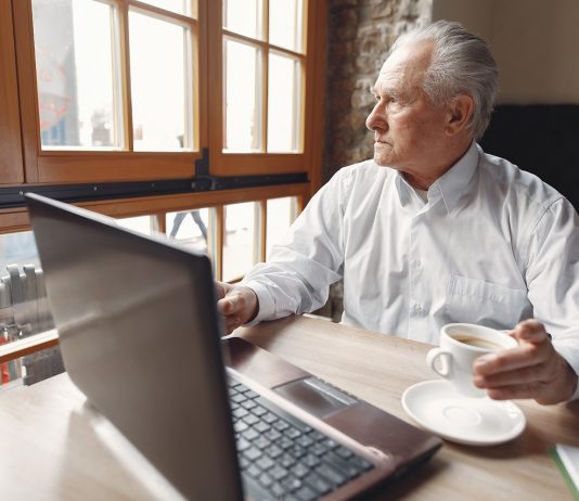 Romániában lehetővé tennék a munkaviszony fenntartását a nyugdíjkorhatár elérése után Old man sitting at the table and working with a laptop