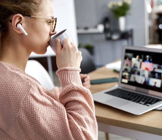 Kávét? Teát? Energiaitalt? Young female teacher drinking coffee during online class