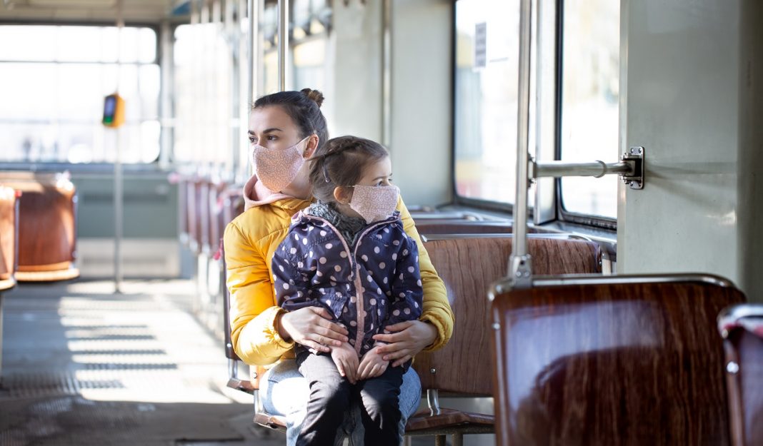 Mother and child in public transport, wearing masks . during a pandemic.