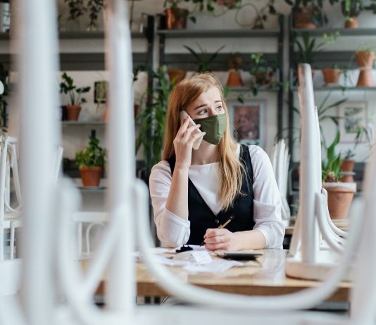 A munkanélküliek ötöde fiatal Frustrated owner sitting at table in closed cafe, small business lockdown due to coronavirus.