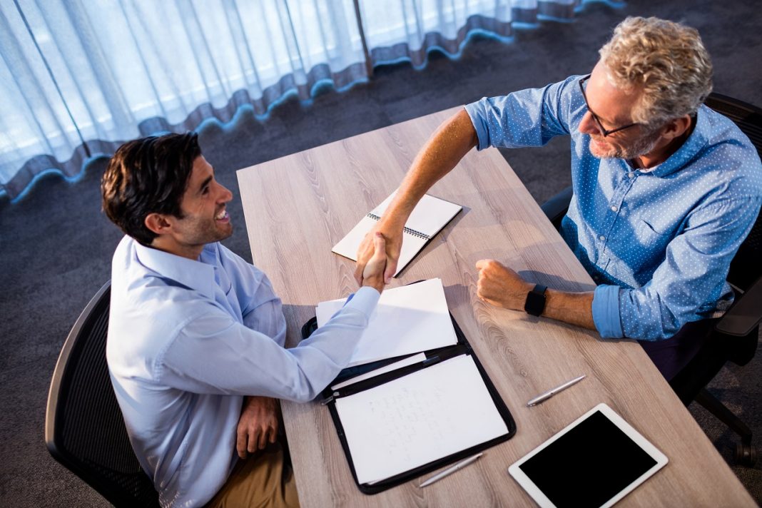 Two businessmen giving a handshake in the office