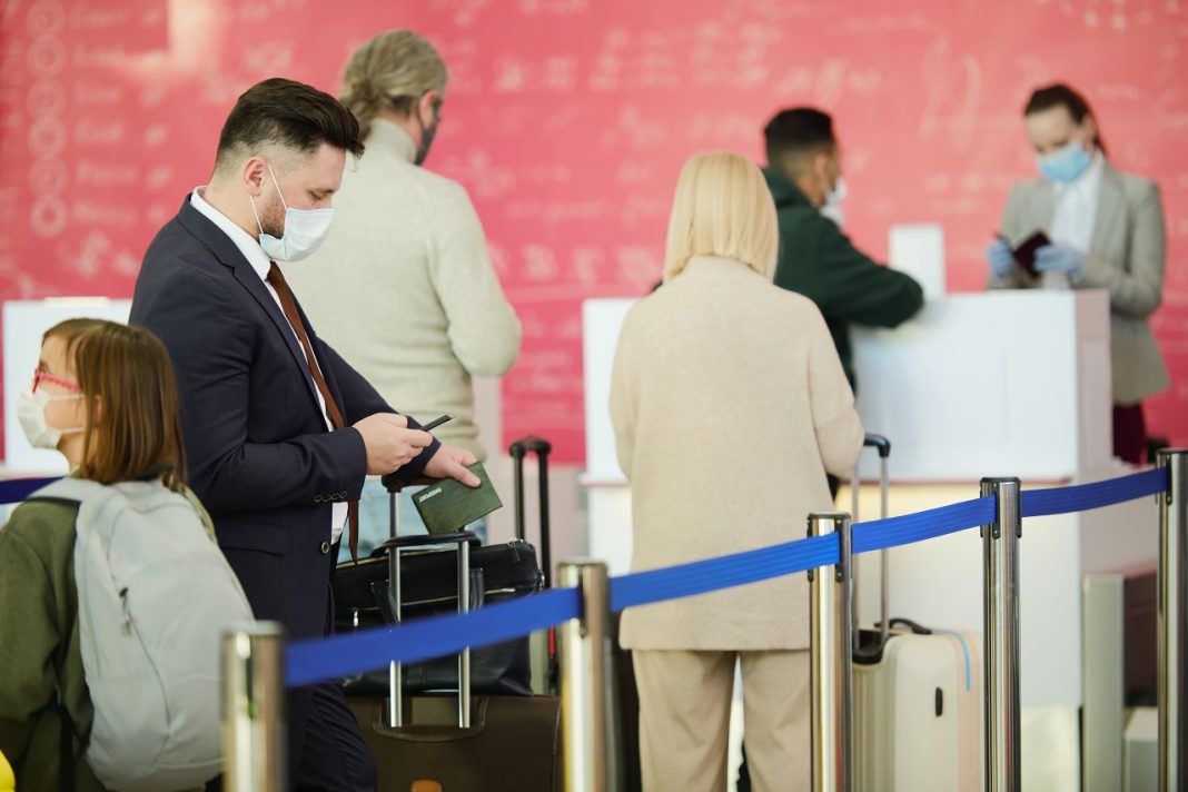 Travellers standing in queue