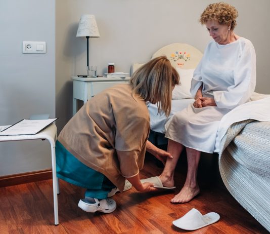 Veszélyben a szociális szakmák Carer wearing slippers to elderly patient