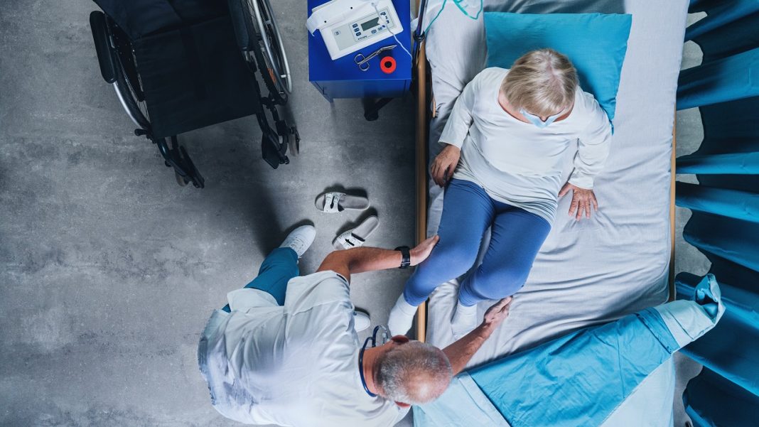 Már ötszáz önkéntes jelentkezett a Covid betegek mellé Top view of doctor putting covid-19 patient in bed in hospital, coronavirus concept.
