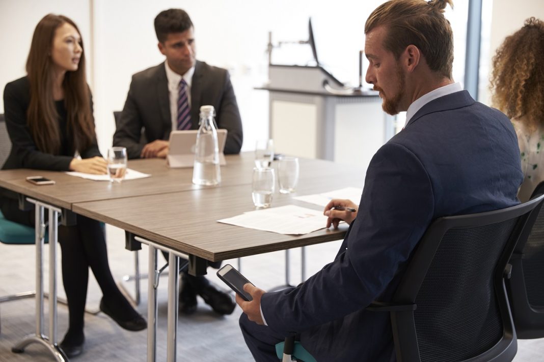 A titoktartási kötelezettség és a versenytilalom közti különbség Businessman Receiving Text Message During Meeting