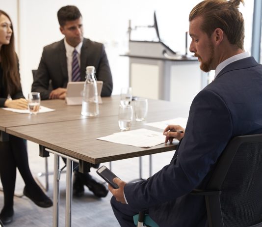 A titoktartási kötelezettség és a versenytilalom közti különbség Businessman Receiving Text Message During Meeting