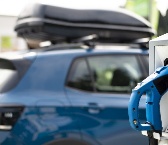 Belehúznak a németek az e-autógyártásba Electric car on gas station. Blue car and electric plug for char