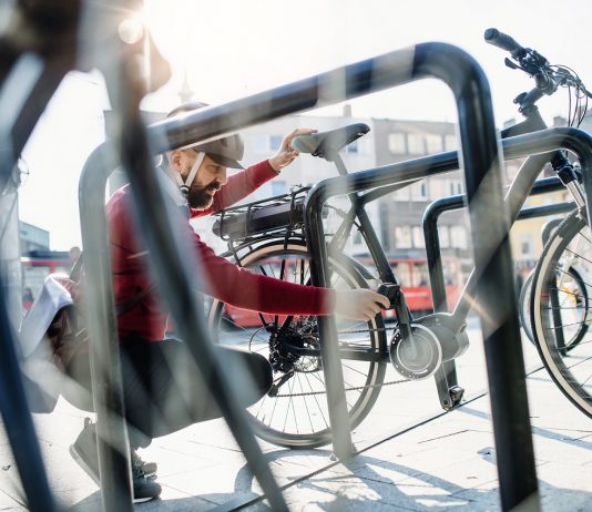 Adásvételi szerződés nélkül is igényelhető a támogatás az e-kerékpárra Hipster businessman commuter parking electric bicycle in city when going to work.