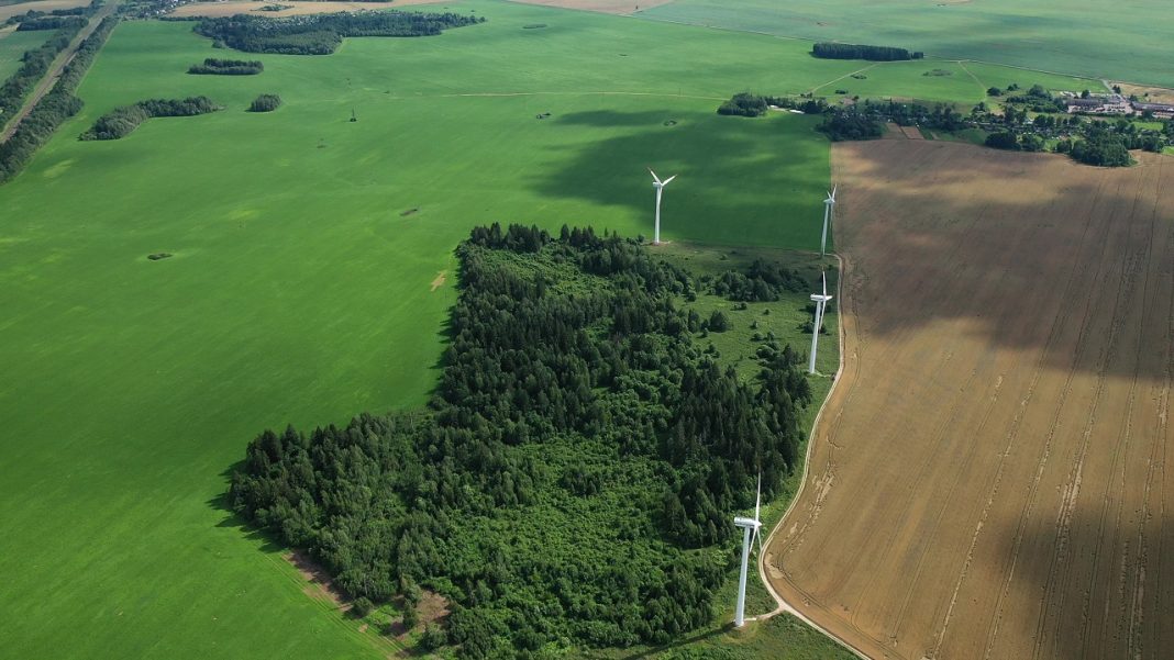 Windmills in summer in a green field.large windmills standing in a field near the forest.Europe, Belarus