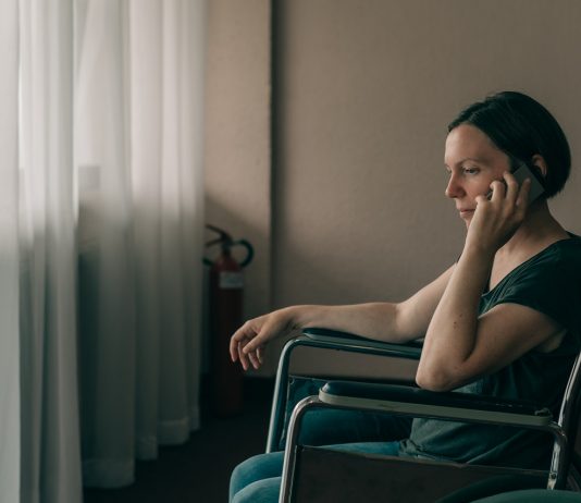 Emberi oldal: kézzel fogható segítség a munkaerőpiacon nehéz helyzetben lévőknek Hopeful female person with disability talking on mobile phone