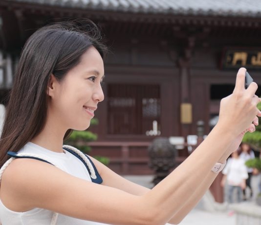 A kínaiak többet utaznak, mint a járvány előtt Travel woman use of mobile phone to take photo in Chinese garden