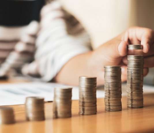 A magyarok harmadának nincs félretett pénze – akinek van megtakarítása, az utazásra költene Woman's hand. Place a coin on the coin graph with coins, saving