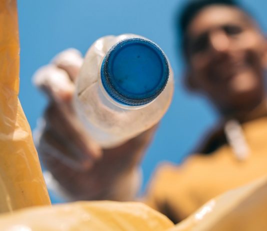 A műanyag fenntartható alapanyaggá válhat a jövőben Young man throwing plastic bottles in the trash