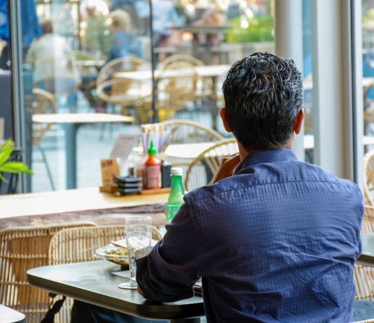 Szerbiában kinyithatnak az éttermek és kávézók kerthelyiségei Man from behind sits in a modern restaurant and looks outside. H