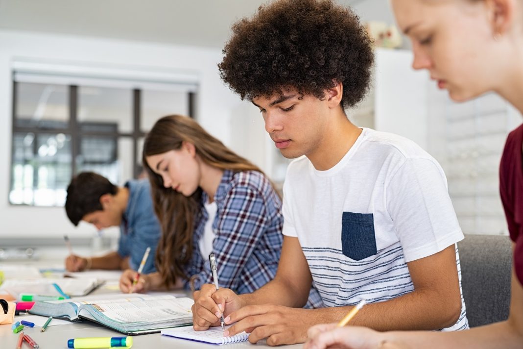 High school student guy studying in classroom