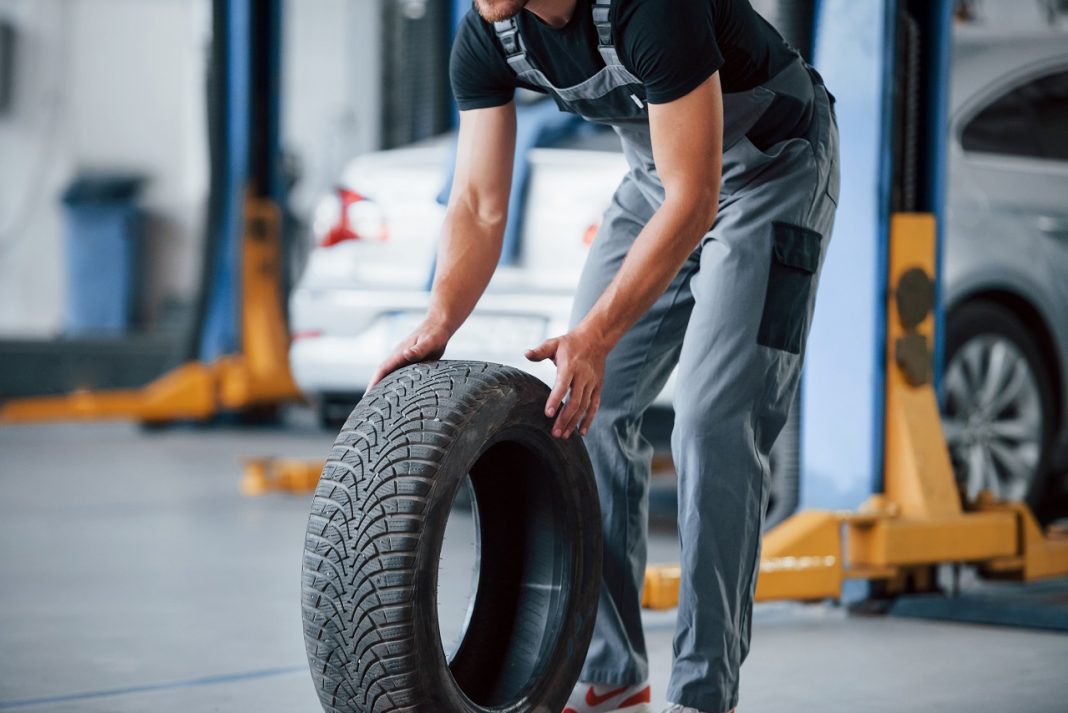 Minden tizedik pályaváltó a koronavírus miatt keres új szakmát It's easier to walk that way. Mechanic holds a tire at the repair garage. Replacement of winter and summer tires