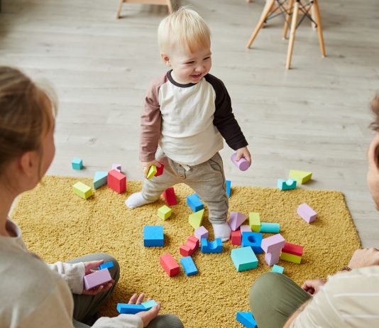 A gyerekekkel együtt örülnek a játékkereskedők Child playing with parents