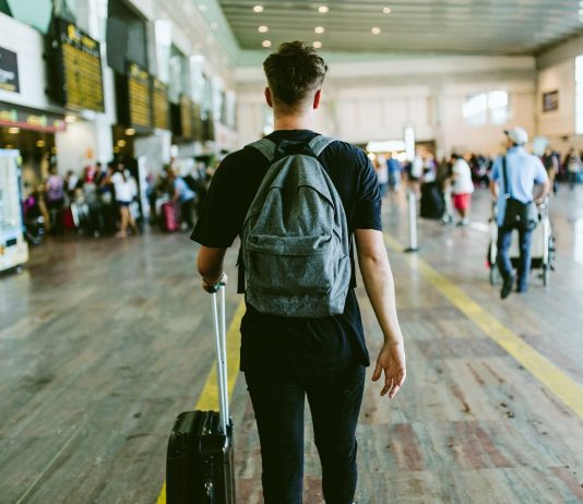 Külföldi munka – a saját bőrünket visszük a vásárra Handsome young man walking in the airport.