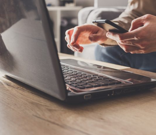 A tűzzel játszik, aki csak úgy belenéz az alkalmazott levelezésébe Close up of business man working on laptop computer and smartphone, sending email working from home