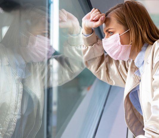 50 ezer munkanélkülit akar visszavezetni a munka világába Ausztria Depressed woman wearing medical face mask, looking out the windo