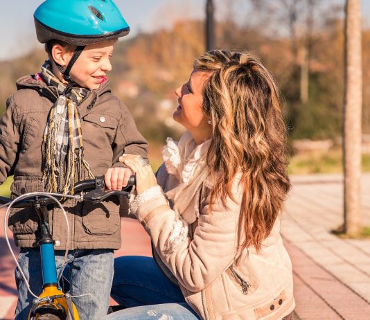 Az örök visszatérő kérdés: gyermekvállalás után visszatérő édesanya és a felhalmozódott szabadság Young woman with child over bicycle on sunny day