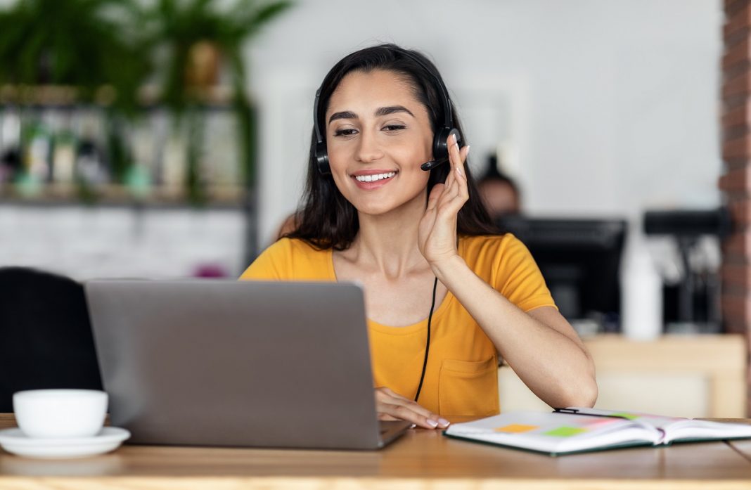 Young woman having job interview online, sitting at cafe
