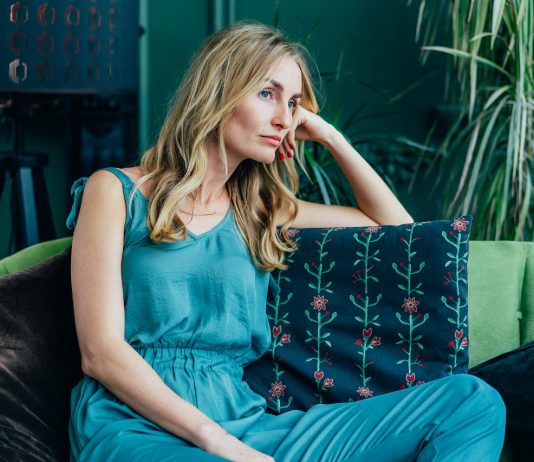 A flowra várva: Hogyan lehet elérni a flowt? Young attractive Caucasian blonde is sitting bored on the sofa.