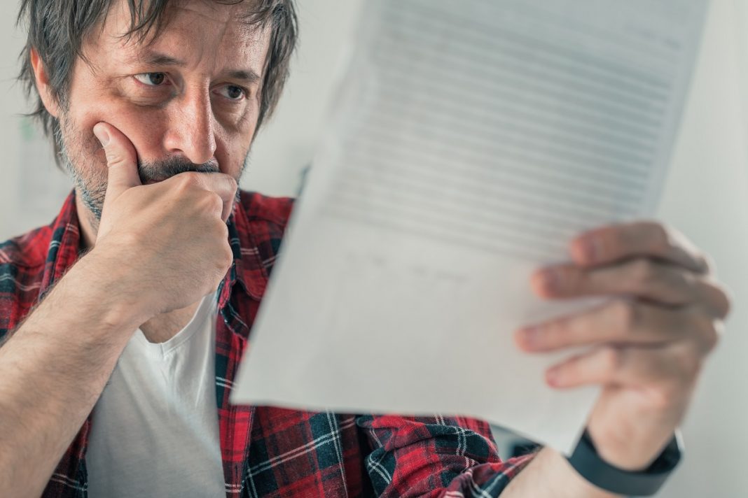 Worried freelancer reading business contract and terms of servic