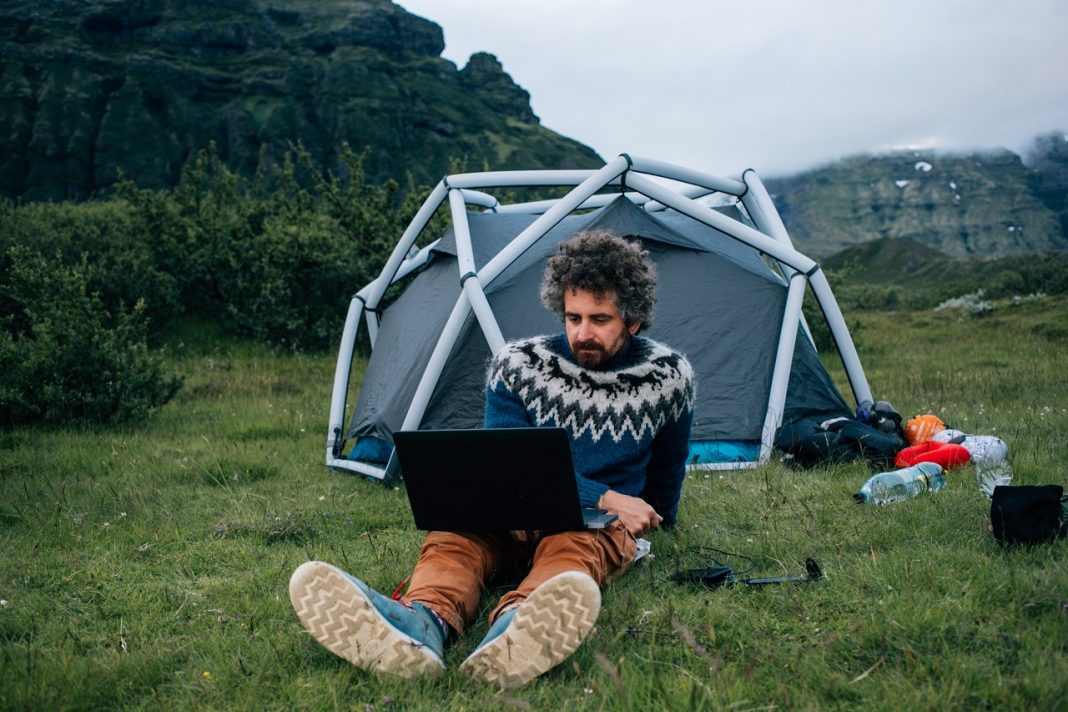 Ősember a billentyűzetnél Man sit in front of campign tent with laptop