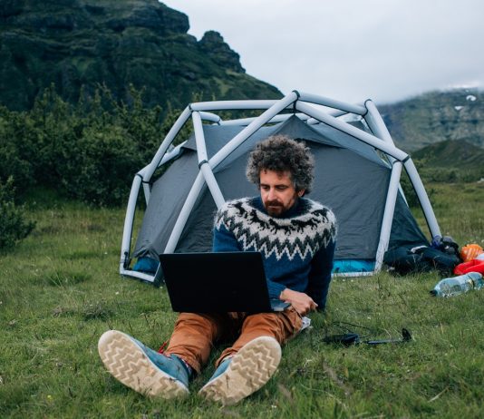 Ősember a billentyűzetnél Man sit in front of campign tent with laptop