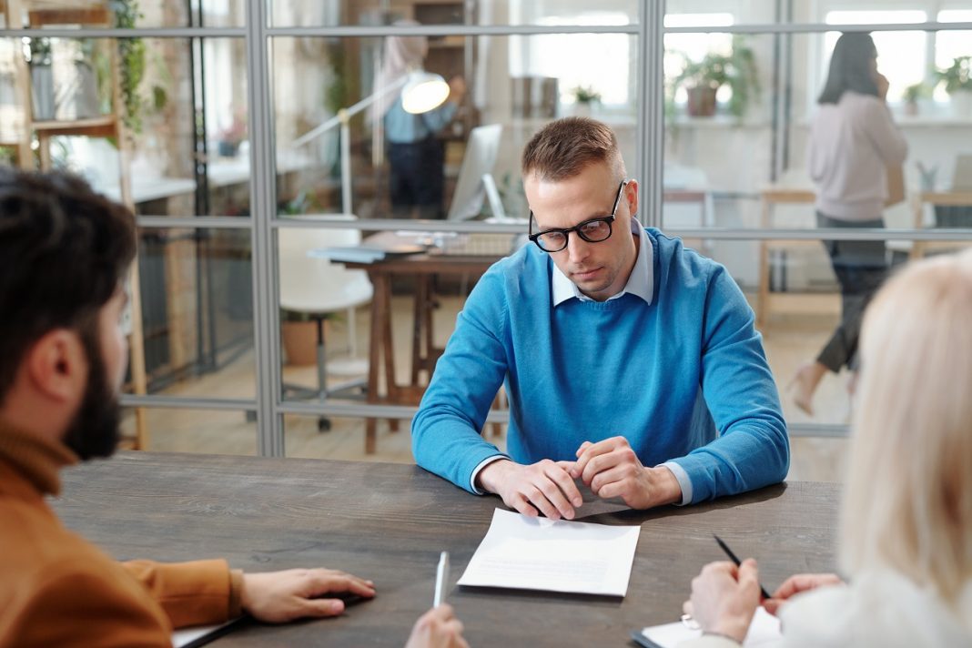 Handsome man reading contract at job interview