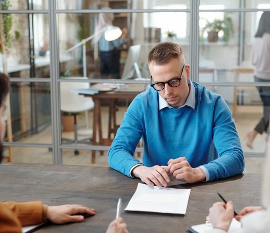 A pálya széléről: határozott idejű szerződéssel Handsome man reading contract at job interview